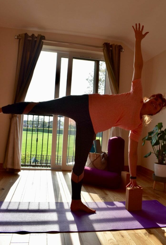 a woman doing a yoga pose on a yoga mat.