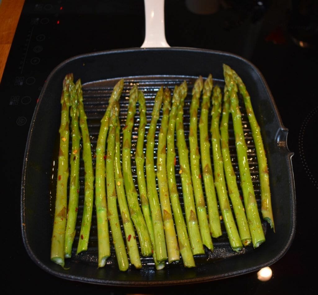 asparagus being cooked in a pan on the stove.