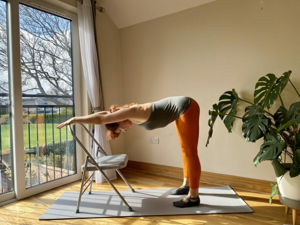 a woman doing a yoga pose in a room.