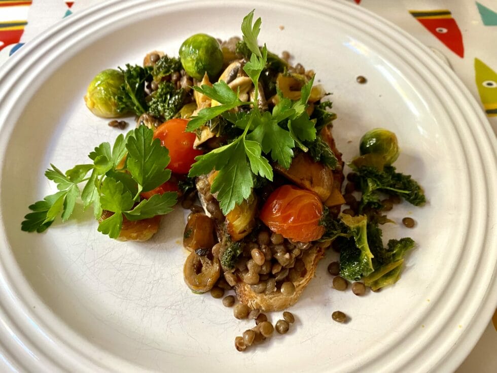 a white plate topped with vegetables and lentils.